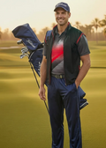 Man holding a golf bag on a golf course with palm trees in the background